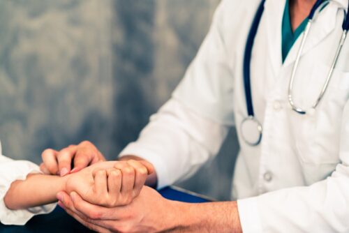 orthopedic surgeon examining a patient's wrist